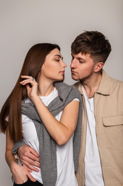 Mooie stijlvolle jonge paar, man en vrouw, in modieuze vrijetijdskleding, poseren in de studio