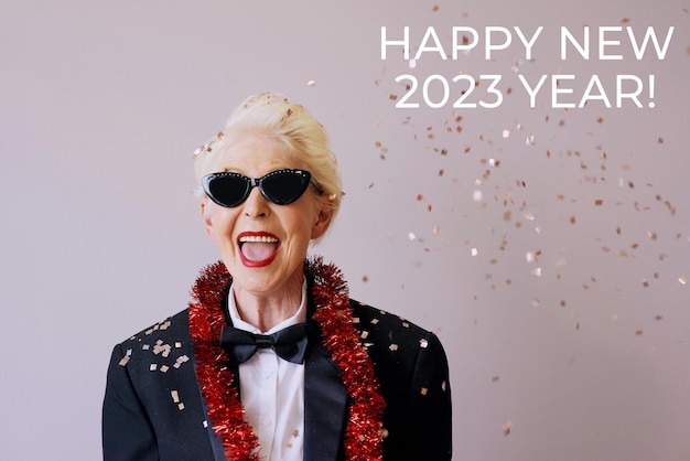 Mooie stijlvolle volwassen senior vrouw in zonnebril en smoking Nieuwjaar vieren. Leuk feestje