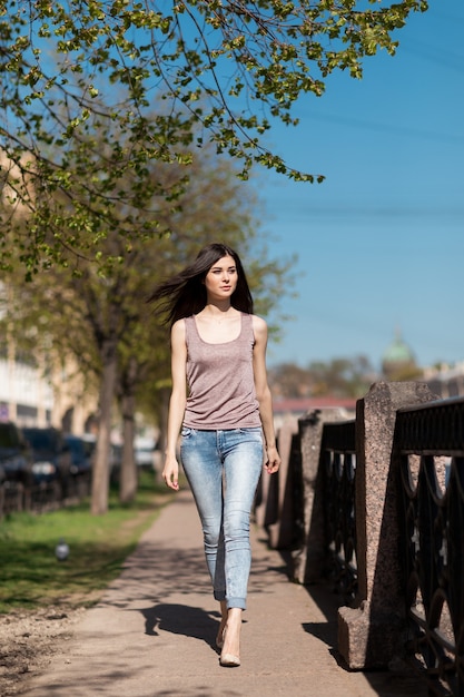 Mooie stijlvolle vrouw die door de stad loopt