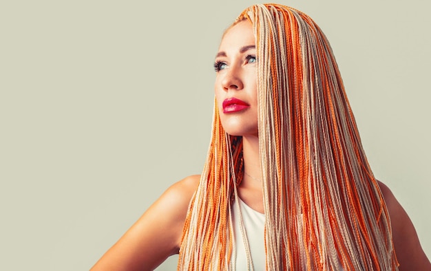 Mooie stijlvolle vrouw met kleurrijke kanekalon gevlochten in haar haar Mooie vrouw kleurrijke oranje haar vlechten Kapsalon concept