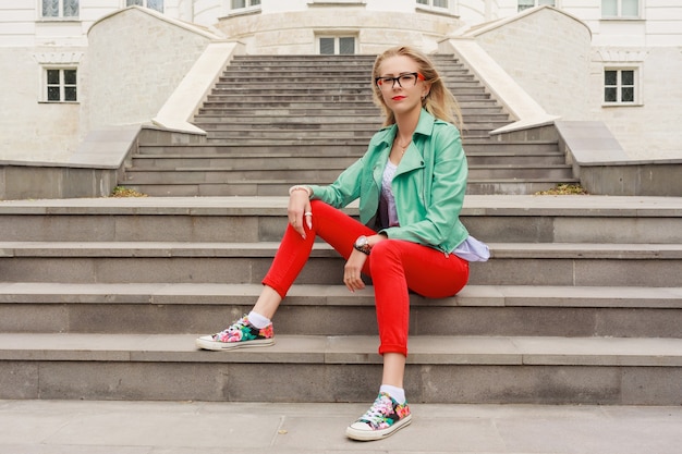 Mooie stijlvolle vrouw zittend op trappen