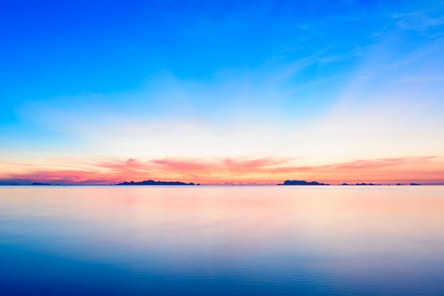 Mooie strandzonsondergang met blauwe overzees en gouden lichte hemelwolk