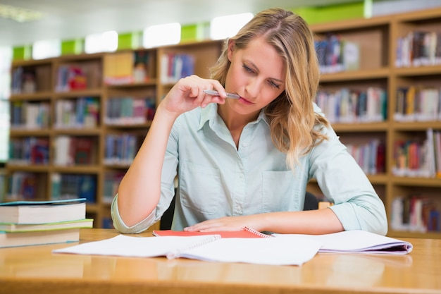 Mooie student die in de bibliotheek bestudeert