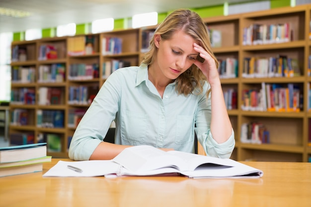 Mooie student die in de bibliotheek bestudeert