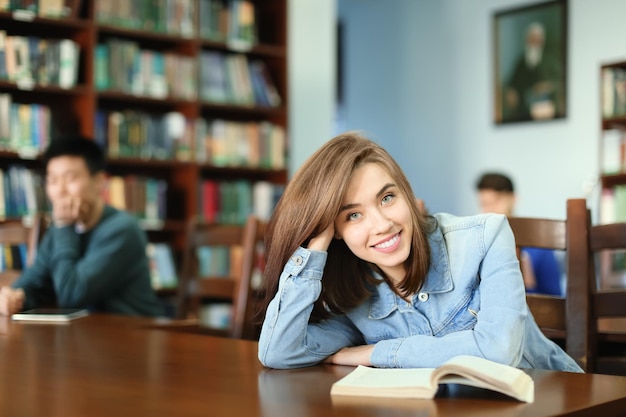 Mooie student met boek studeren in de bibliotheek