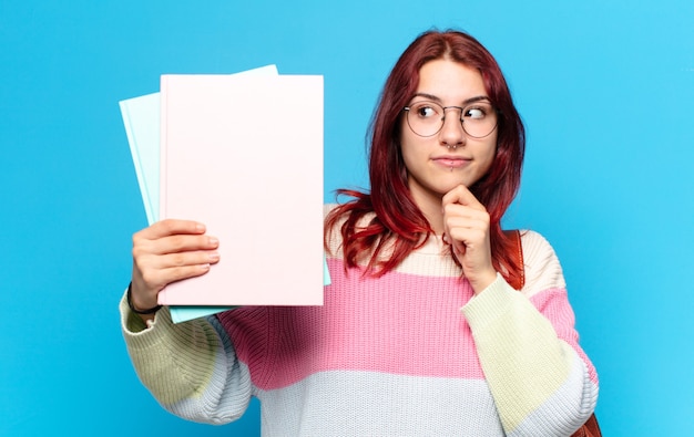 Mooie studentenvrouw die kleurrijke documenten houdt