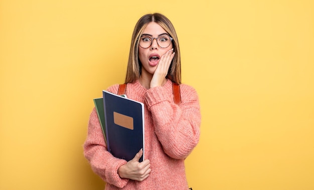 Mooie studentenvrouw die zich geschokt en bang voelt. boeken en rugzak