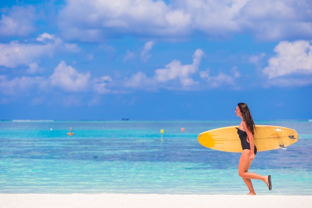 Mooie surfervrouw die tijdens de zomervakantie surfen