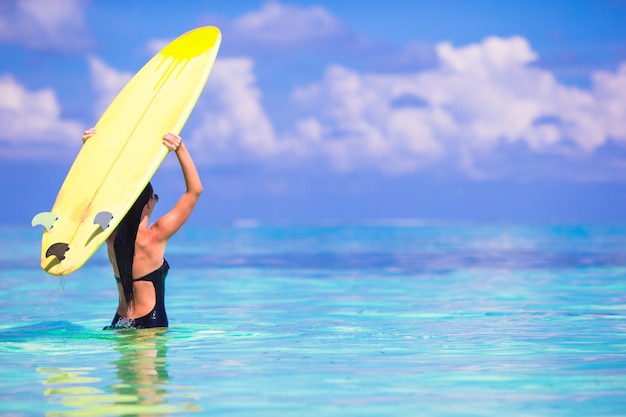 Mooie surfervrouw die tijdens de zomervakantie surfen