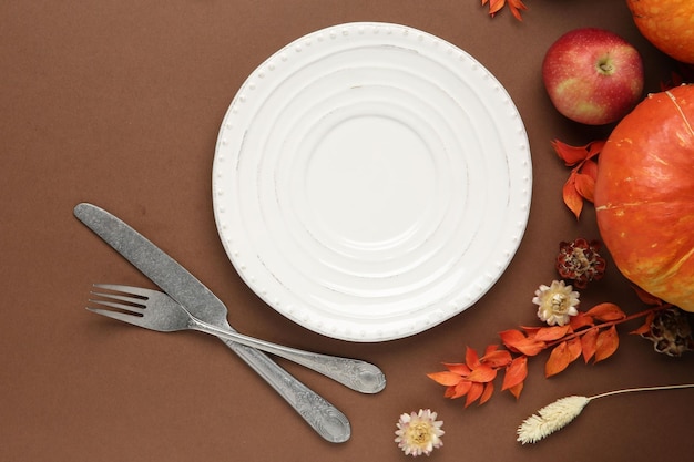 Mooie tafelinrichting met herfstdecoratie op bruine achtergrond