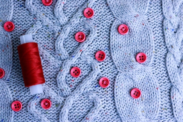 Mooie textuur van een zachte, warme, natuurlijke sweaterstof met een gebreid patroon van garen en rood