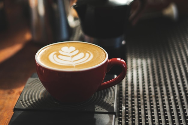 Mooie textuur van Latte-kunst op hete latte-koffie Melkschuim in hartvormbladboom bovenop latte-kunst van professionele barista-kunstenaar