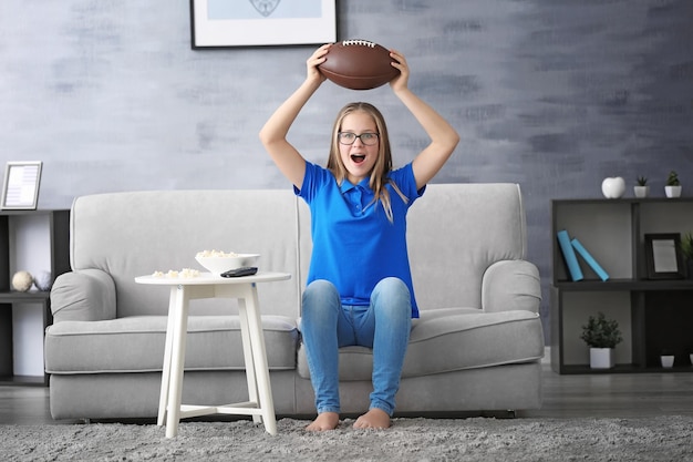 Mooie tiener die thuis rugby op tv kijkt