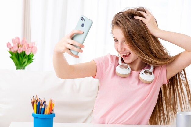 Mooie tiener selfie maken van zichzelf in coole hoofdtelefoon