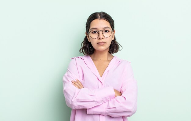 Mooie tienervrouw die zich ontevreden en teleurgesteld voelt, er serieus, geïrriteerd en boos uitziet met gekruiste armen