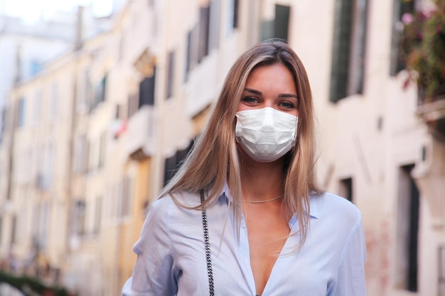 Mooie toeristenvrouw met corona-virusmasker op het eiland Venetië in Italië