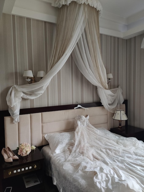 Mooie trouwjurk van de bruid ligt op het bed in de kamer
