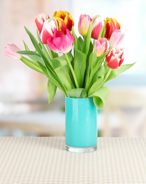 Mooie tulpen in emmer op tafel in kamer