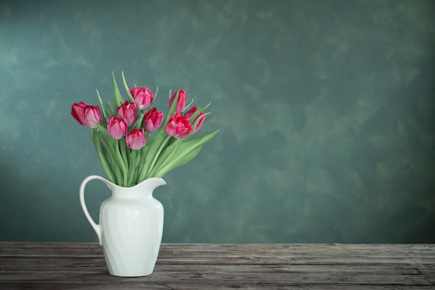 Mooie tulpen in witte kruik op donker