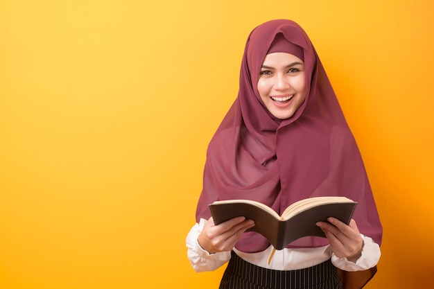 Mooie universitaire student met hijab portret op gele achtergrond