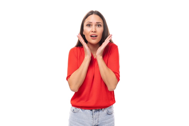 Mooie verbaasde brunette vrouw in rood stijlvolle vneck blouse op witte achtergrond met kopieerruimte