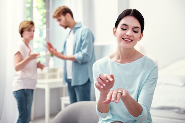 Mooie verloofde. Blije gelukkige vrouw die lacht terwijl ze naar haar verlovingsring kijkt