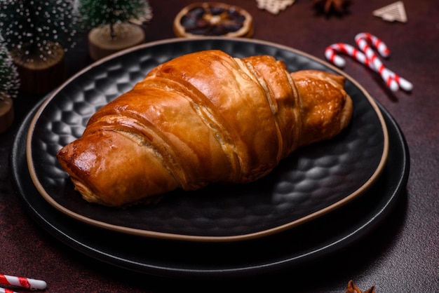 Mooie verschillende kerstversieringen en croissants op een bruine betonnen tafel