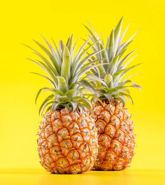 Mooie verse ananas geïsoleerd op felgele achtergrond zomer seizoensfruit ontwerp idee patroon concept kopie ruimte close-up