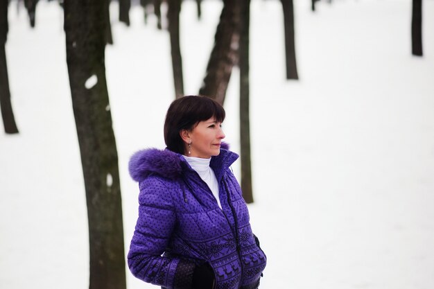 Mooie volwassen vrouw die van een de winterdag geniet