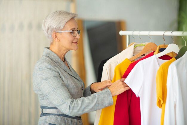 mooie volwassen vrouw in pak kiest kleding