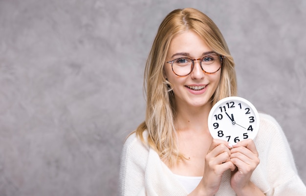 Mooie volwassen vrouw met klok