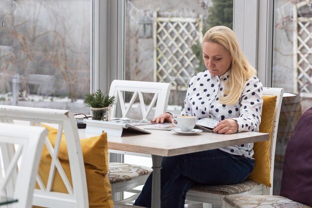 Mooie volwassen vrouw zakenvrouw met blond haar losse werken in de koffie