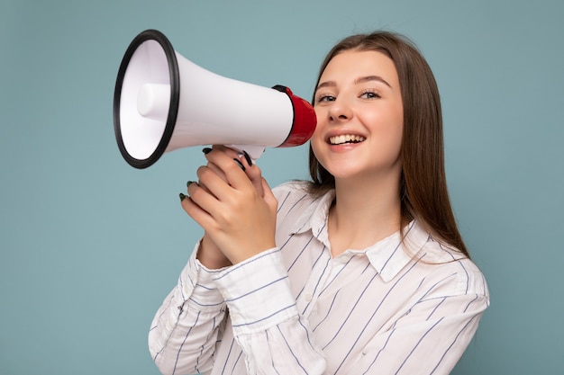 Mooie, vrij positieve, gelukkig lachende donkerblonde jonge vrouw met oprechte emoties die casual draagt