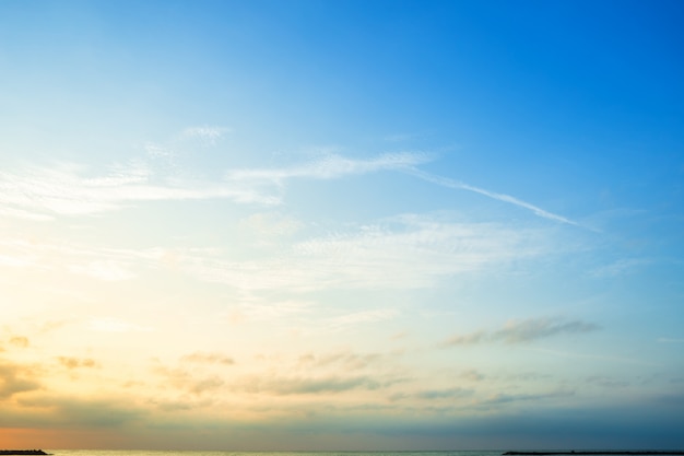 Mooie vroege ochtendzonsopgang over het overzees de horizon, blauwe hemeltextuur als achtergrond met witte wolkenzonsondergang.