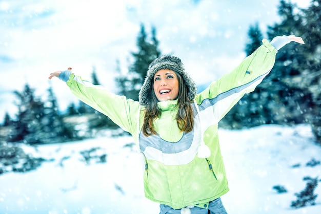 Mooie vrolijke jonge vrouw genieten in skivakanties en zonnige winterdag.