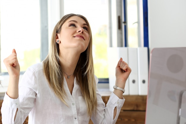 Mooie vrolijke vrouw op de werkplek met behulp van computer pc