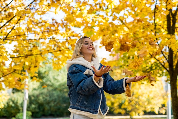 Foto mooie vrouw alleen wandelen buiten in het herfstpark genieten van vrije tijd in de natuur genieten van zonnig weer