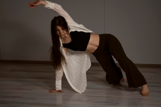 Mooie vrouw balletdanser in zwarte zwembroek poseren op lichtgrijze studio achtergrond Animal