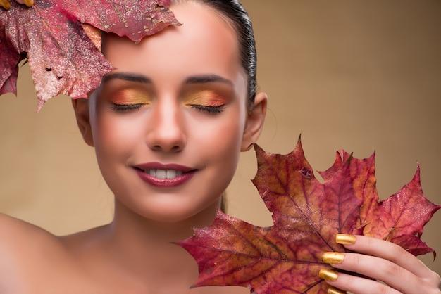 Mooie vrouw binnen met de herfst droge bladeren