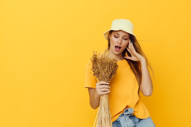 Mooie vrouw boeket gedroogde bloemen vrijetijdskleding glimlach poseren geïsoleerde achtergrond