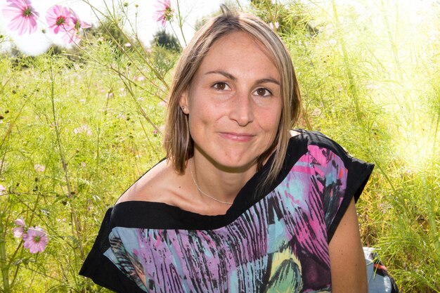 Mooie vrouw buitenshuis op groen gras bloemen achtergrond in de lente romantische mooie dag