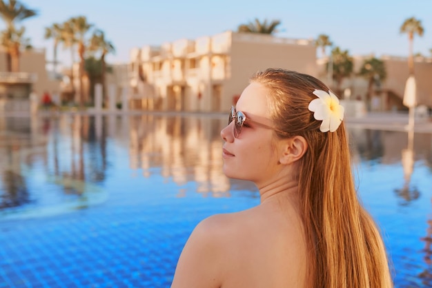 Mooie vrouw chillen bij het zwembad Zomerrecreatie reisconcept