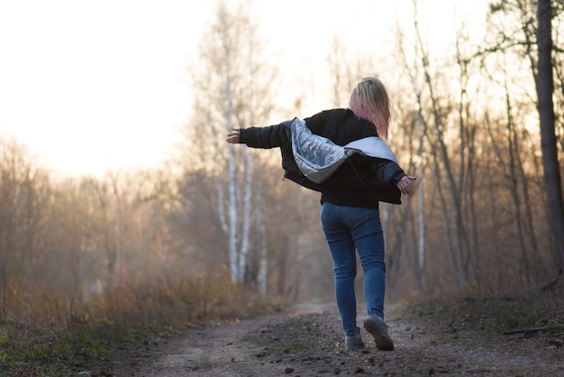 Mooie vrouw danst buiten in de lentezonsondergang