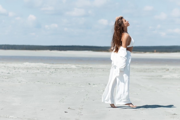 Mooie vrouw die aan de kust staat