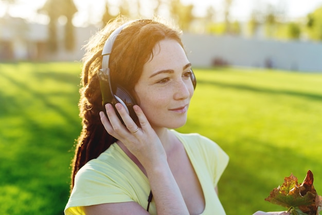 Mooie vrouw die aan muziek met haar hoofdtelefoons luistert