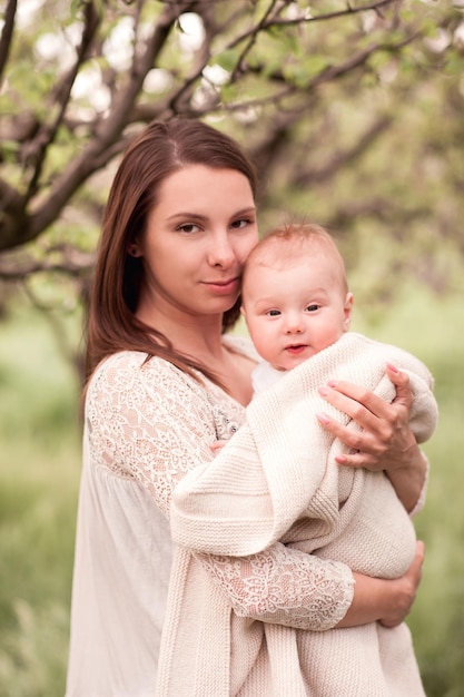 Mooie vrouw die babyjongen buiten vasthoudt