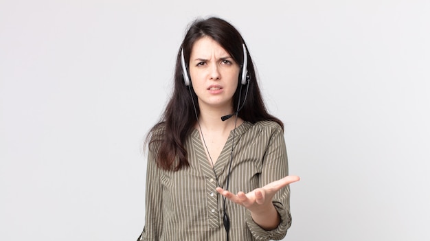 Mooie vrouw die boos, geïrriteerd en gefrustreerd kijkt. assistent-agent met een headset