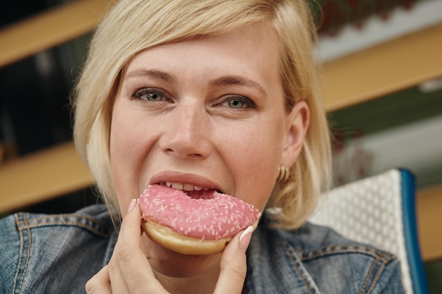 Foto mooie vrouw die chocoladecake eet bij café