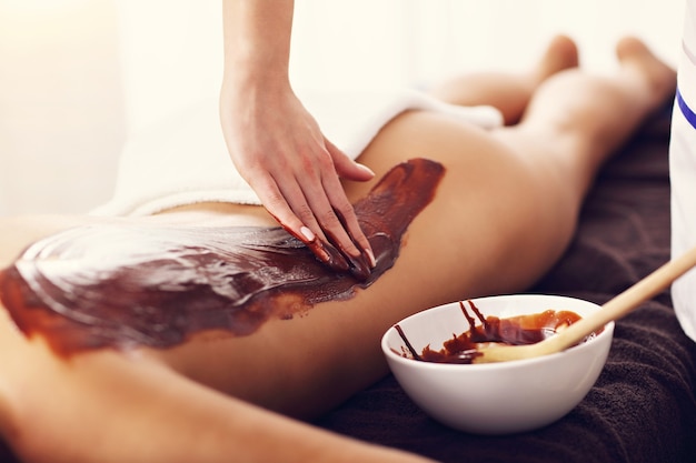 mooie vrouw die chocolademassage krijgt in spa