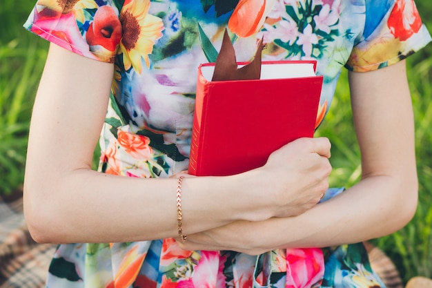 Mooie vrouw die een boek in de de lentetuin leest